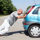 Čovjek koji gura automobil