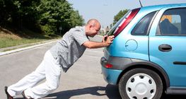 Čovjek koji gura automobil